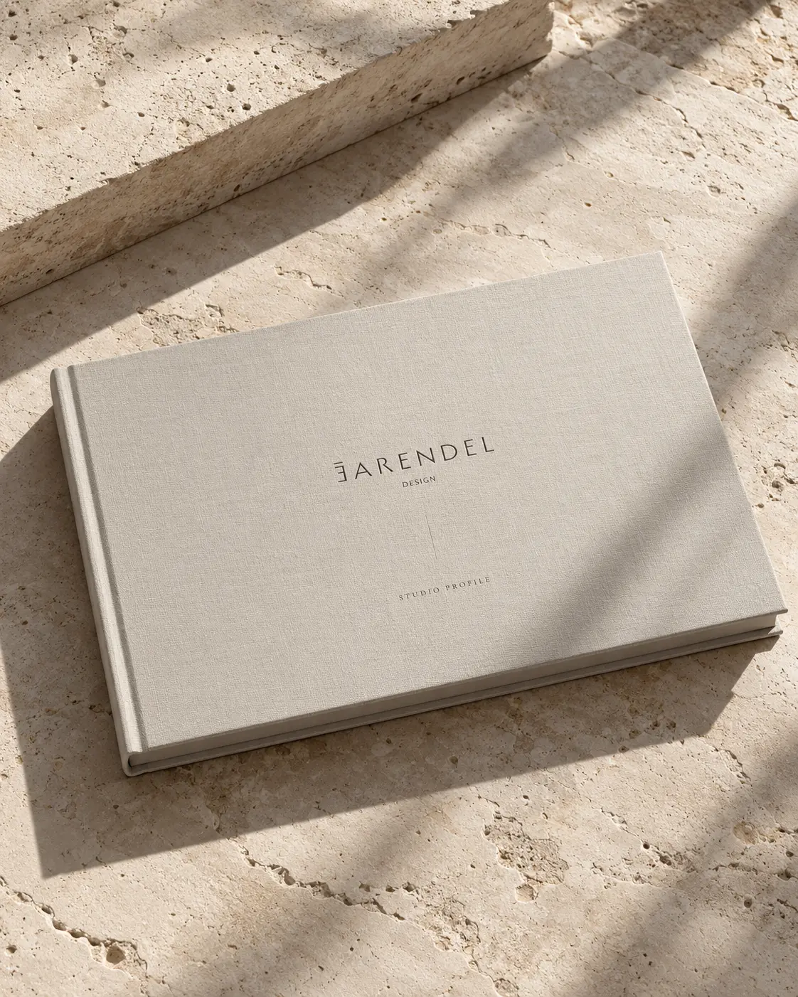 Earendel Design Studio Profile book resting on a travertine surface in warm daylight