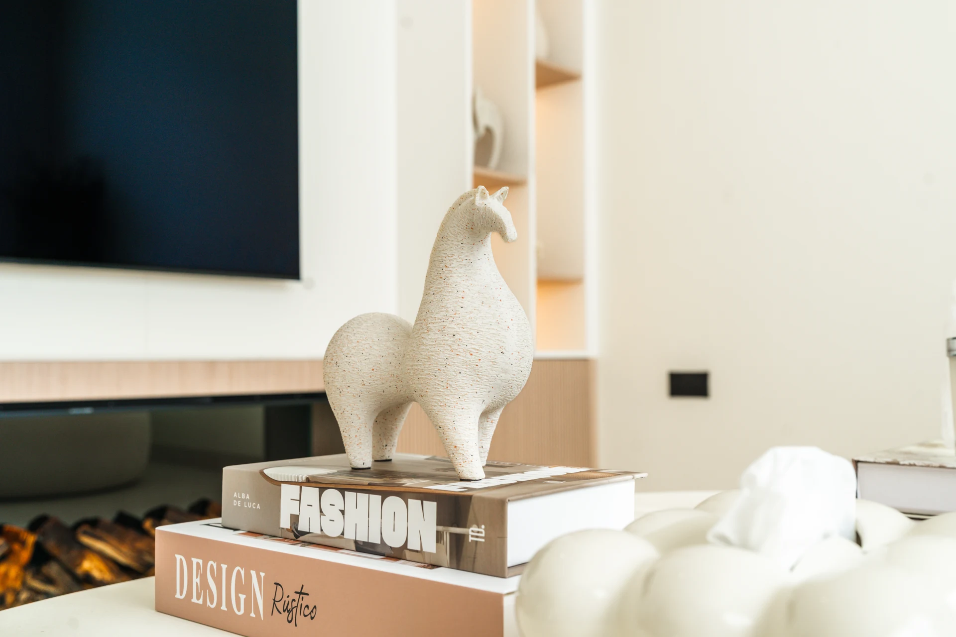 Maple Villa — A restrained arrangement of books and sculptural objects brings character to the quiet interior.