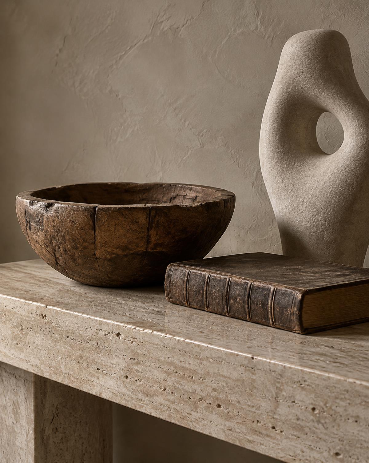 An antique carved bowl and leather-bound book beside a contemporary stone sculpture — Conceptual Design Visualisation.